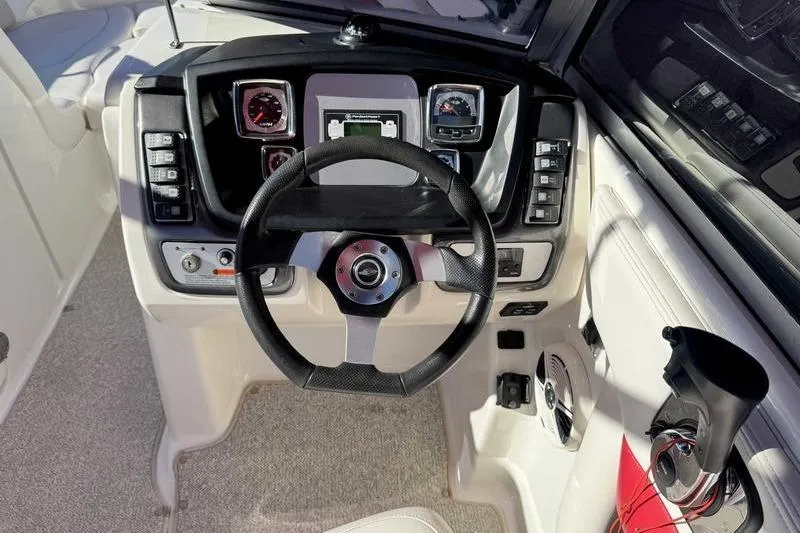 Slide: The Image of 2008 Chaparral 224 Extreme boat dashboard with steering wheel and control panel. - 14