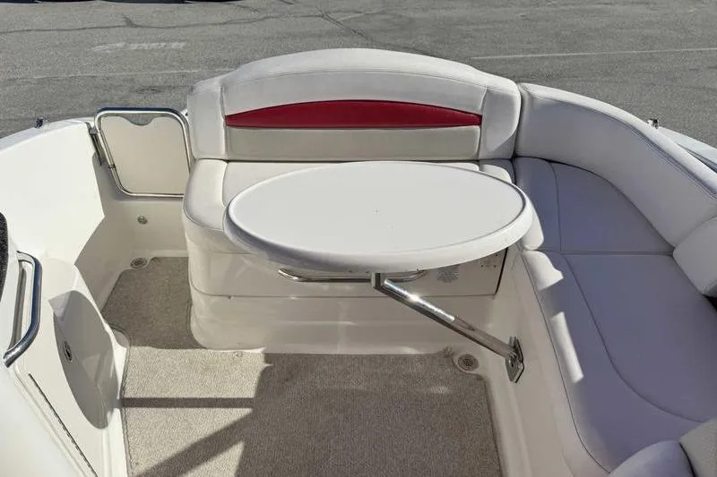 Slide: The Image of 2008 Chaparral 224 Extreme boat interior with round table and cushioned seating. - 15