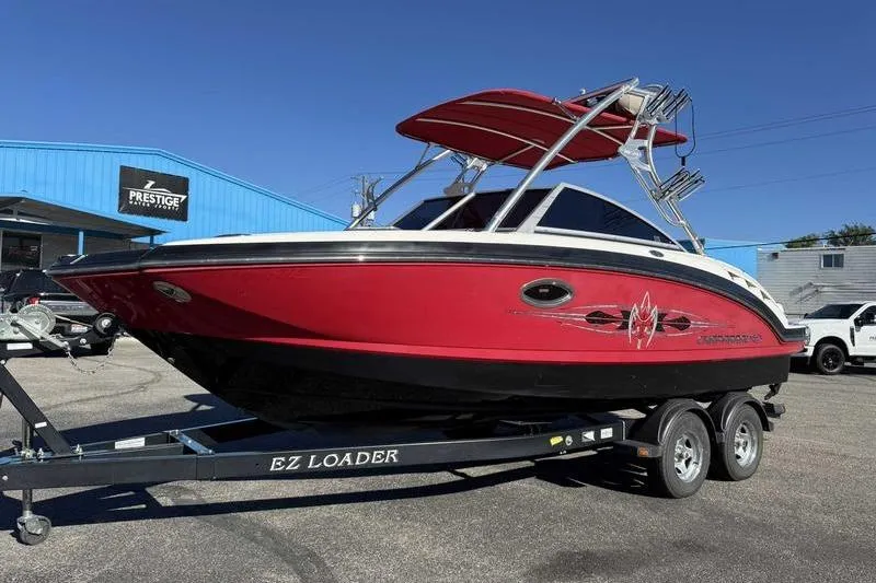 Slide: The Image of 2008 Chaparral 224 Extreme boat on EZ Loader trailer, parked outside a blue building. - 8