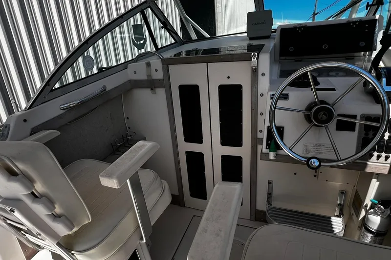Slide: The Image of 1992 Grady-White Explorer 244 boat cockpit with steering wheel and seating. - 10