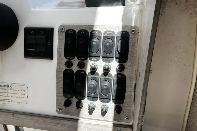 Slide: The Image of Control panel of a 1992 Grady-White Explorer 244 boat with various switches. - 14