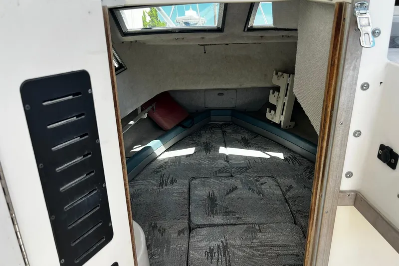 Slide: The Image of 1992 Grady-White Explorer 244 cabin interior with patterned cushions and windows. - 16