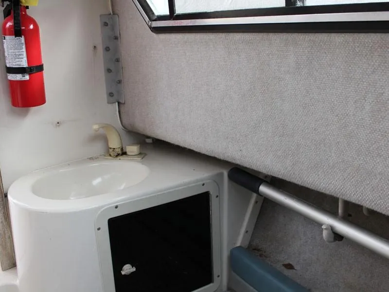 Slide: The Image of 1992 Grady-White Explorer 244 cabin interior with sink and fire extinguisher. - 20