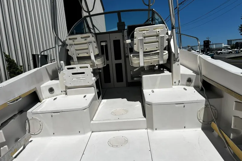 Slide: The Image of 1992 Grady-White Explorer 244 boat interior with dual captain chairs and spacious deck. - 5