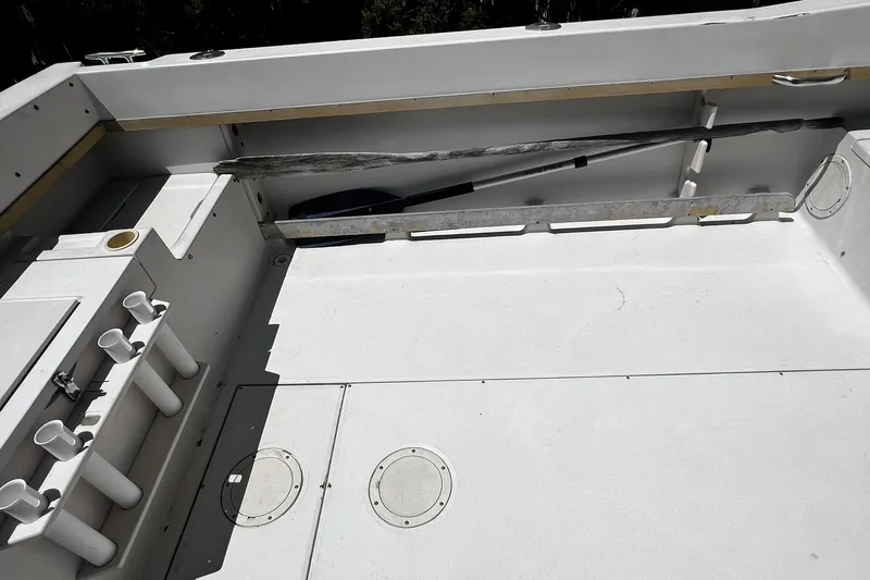 Slide: The Image of 1992 Grady-White Explorer 244 boat interior with rod holders and storage compartments. - 6