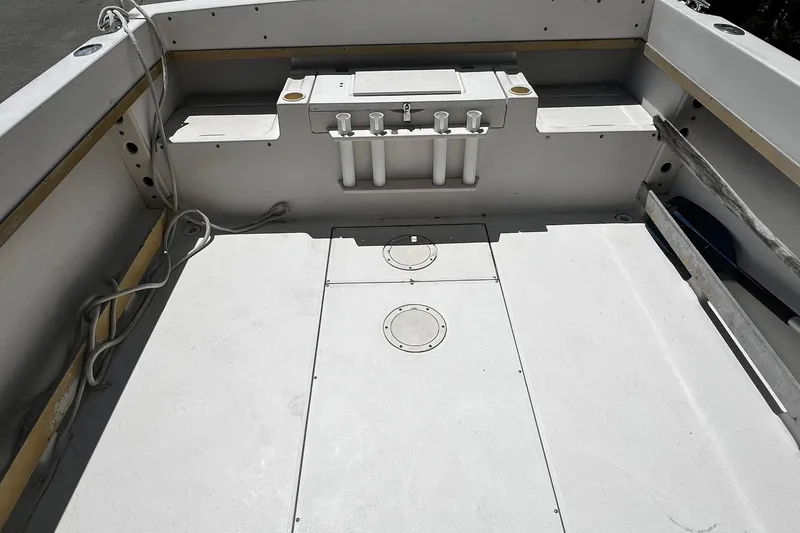 Slide: The Image of 1992 Grady-White Explorer 244 boat interior with storage compartments and rod holders. - 8