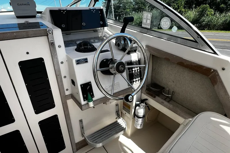 Slide: The Image of 1992 Grady-White Explorer 244 boat cockpit with steering wheel and control panel. - 9