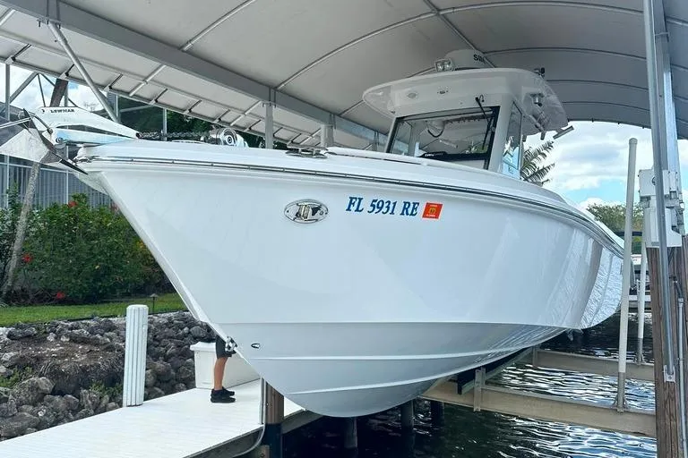 Slide: The Image of 2015 Everglades 295 Center Console boat docked under a canopy. - 13