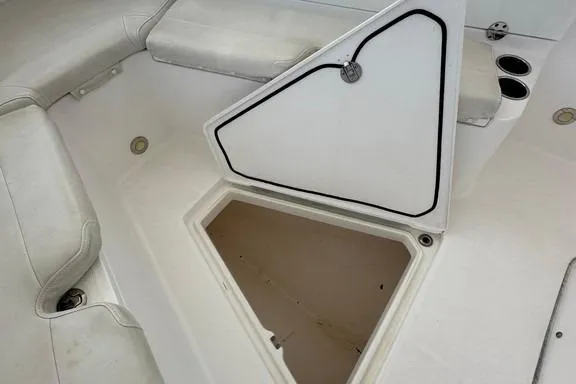 Slide: The Image of 2015 Everglades 295 Center Console boat storage compartment open, white seating visible. - 16