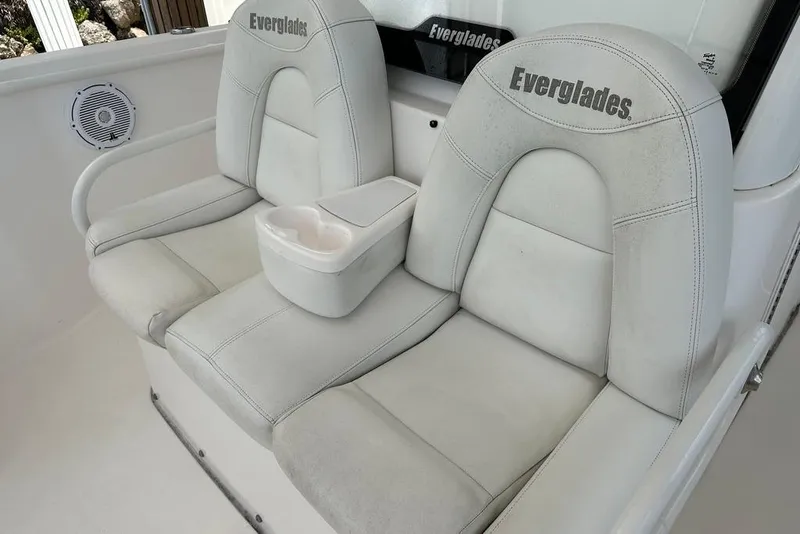 Slide: The Image of 2015 Everglades 295 Center Console boat seats with cup holder, featuring white upholstery. - 22