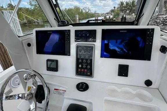 Slide: The Image of 2015 Everglades 295 Center Console boat dashboard with navigation screens and controls. - 34