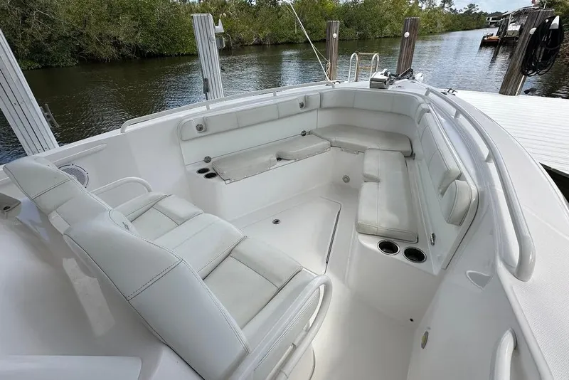 Slide: The Image of 2015 Everglades 295 Center Console boat interior with white seating and cup holders. - 37