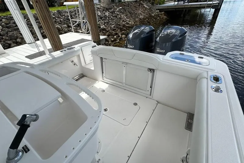 Slide: The Image of 2015 Everglades 295 Center Console boat with twin 300 horsepower engines docked by water. - 41