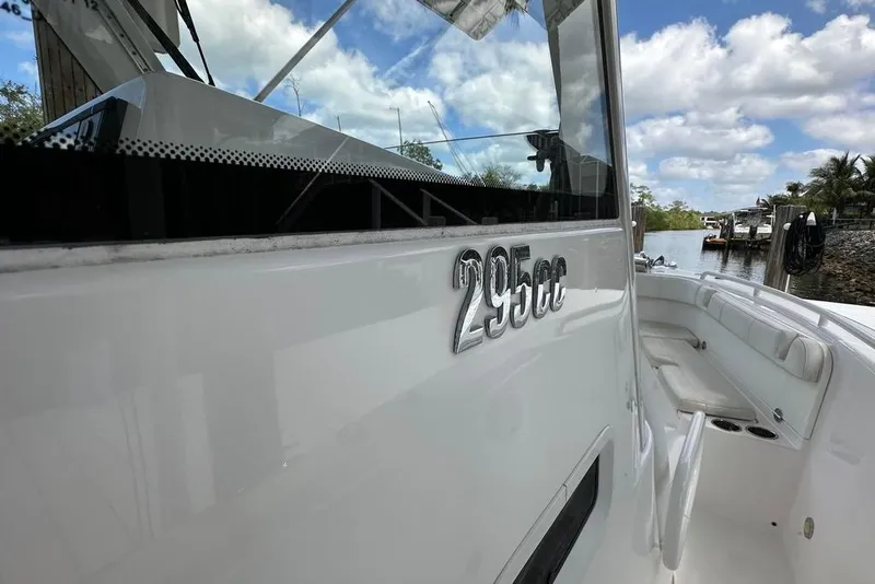 Slide: The Image of 2015 Everglades 295 Center Console boat docked, showcasing sleek design and spacious seating. - 45