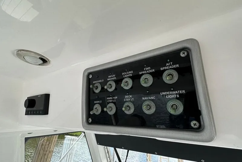 Slide: The Image of Control panel on 2015 Everglades 295 Center Console boat, featuring various light switches. - 46