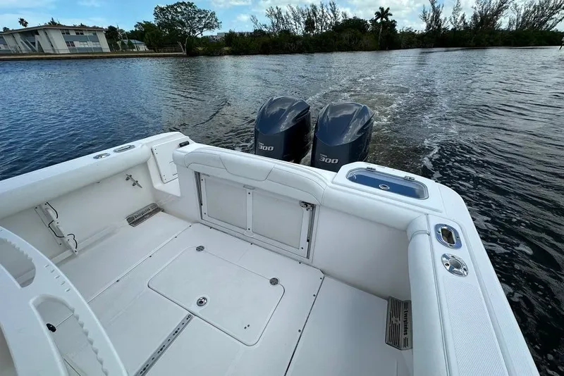 Slide: The Image of 2015 Everglades 295 Center Console boat with dual 300 horsepower engines on a calm waterway. - 47