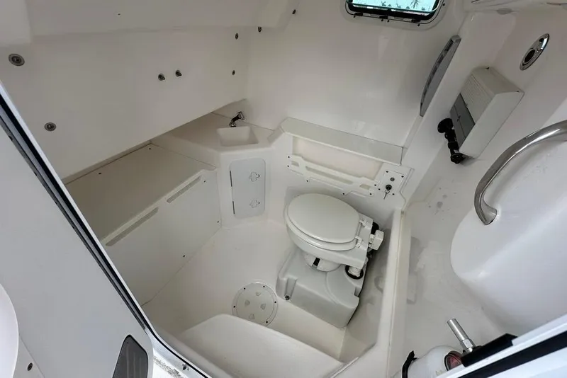 Slide: The Image of 2015 Everglades 295 Center Console boat interior with toilet and sink. - 48
