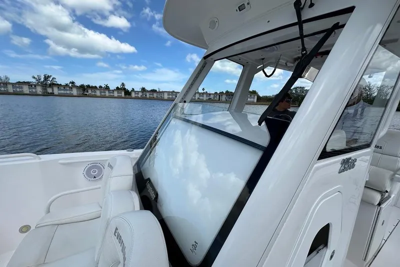 Slide: The Image of 2015 Everglades 295 Center Console boat on calm water, showcasing sleek design and spacious seating. - 50