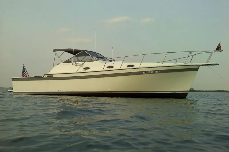 The Image of 1989 Luhrs 35 Alura boat on calm water, featuring sleek design and American flag. - 1
