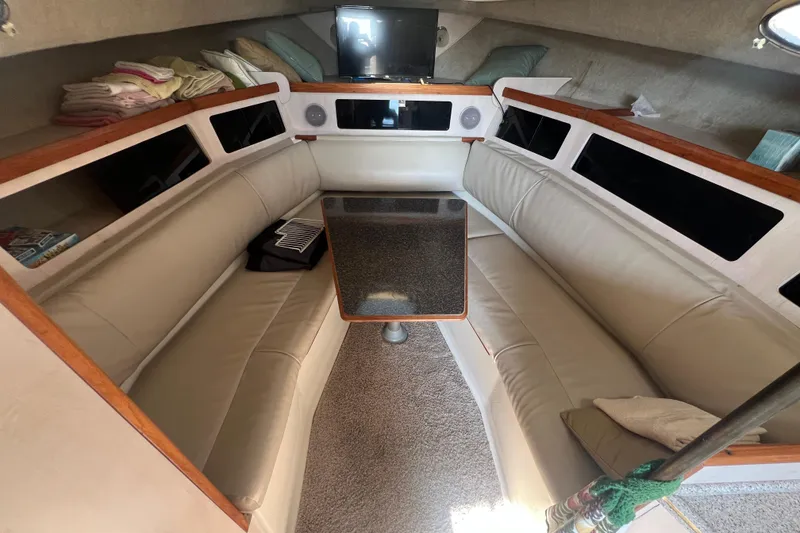 Slide: The Image of 1989 Luhrs 35 Alura cabin interior with beige seating and a central table. - 13