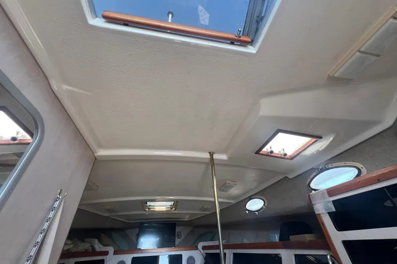 Slide: The Image of Interior view of 1989 Luhrs 35 Alura boat, featuring ceiling hatches and portholes. - 17