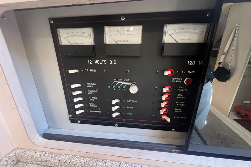 Slide: The Image of Electrical control panel on a 1989 Luhrs 35 Alura boat, showing voltage and amperage gauges. - 19