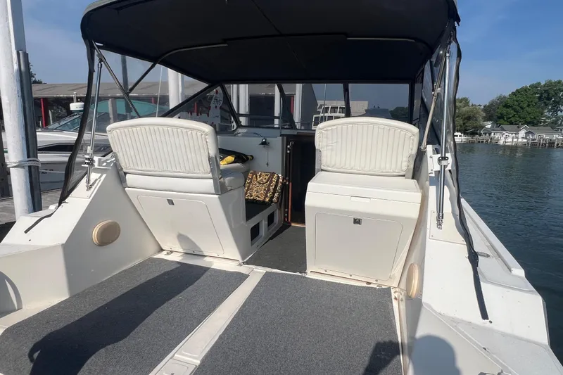 Slide: The Image of 1989 Luhrs 35 Alura boat interior with seating and helm, docked by the water. - 3