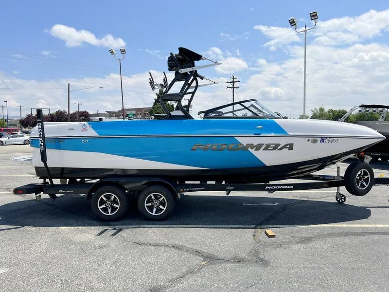 Slide: The Image of 2018 Moomba Mojo™ boat on trailer in parking lot under clear sky. - 10