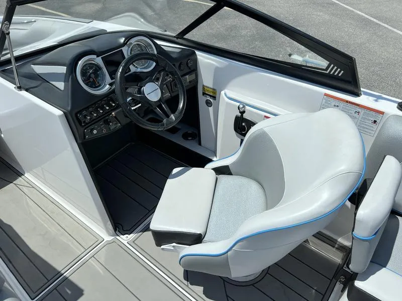 Slide: The Image of 2018 Moomba Mojo™ boat interior with steering wheel, dashboard, and cushioned captain's chair. - 6
