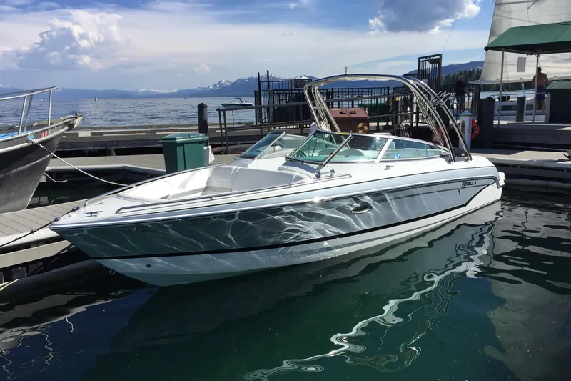 Slide: The Image of 2007 Formula 260 Bowrider boat docked on a sunny day with scenic mountain backdrop. - 2