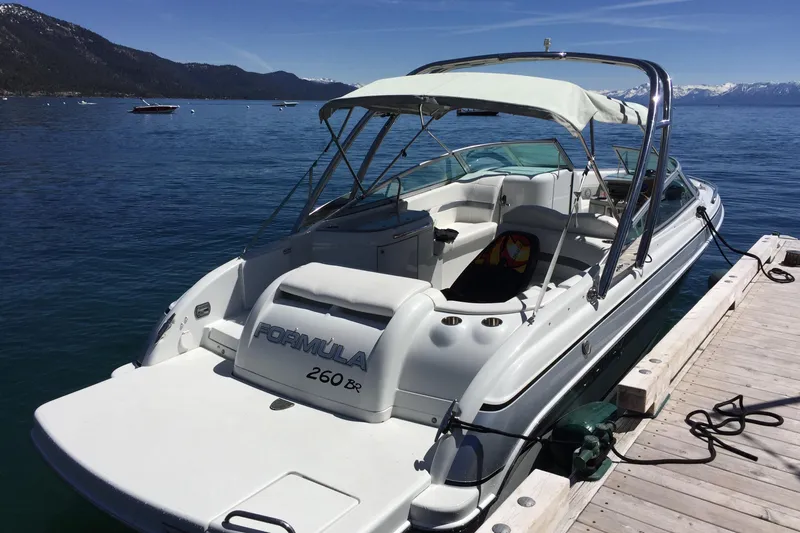 Slide: The Image of 2007 Formula 260 Bowrider docked on a serene lake with mountain views. - 5