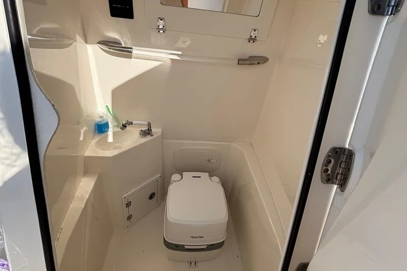 Slide: The Image of 2019 Cobia 240 Center Console boat interior with compact marine toilet. - 4