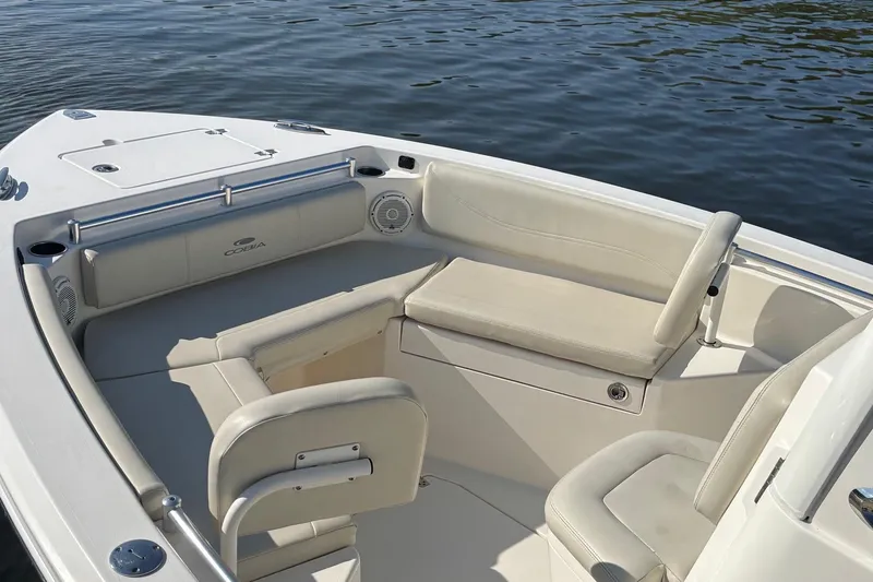 Slide: The Image of 2019 Cobia 240 Center Console boat interior with cushioned seating and water view. - 5
