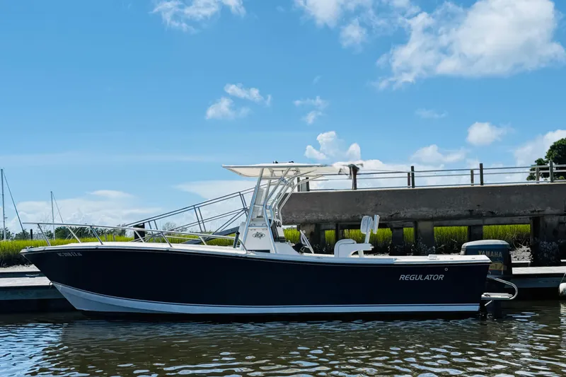 Slide: The Image of 2000 Regulator 23 Classic boat docked under a clear blue sky. - 3