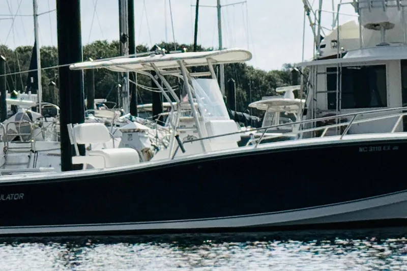 Slide: The Image of 2000 Regulator 23 Classic boat docked in a marina, surrounded by other vessels. - 5