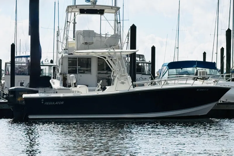 Slide: The Image of 2000 Regulator 23 Classic boat docked at a marina, surrounded by other vessels. - 6