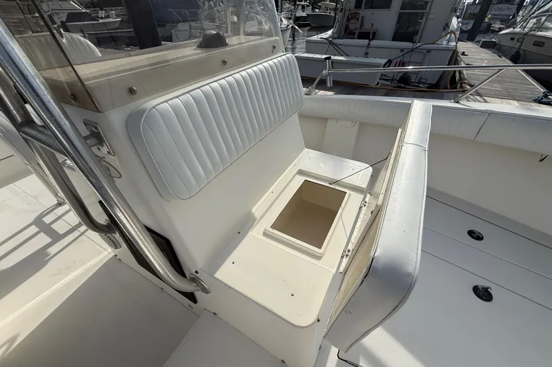 Slide: The Image of 2000 Regulator 23 Classic boat interior with white cushioned seating and storage compartment. - 9
