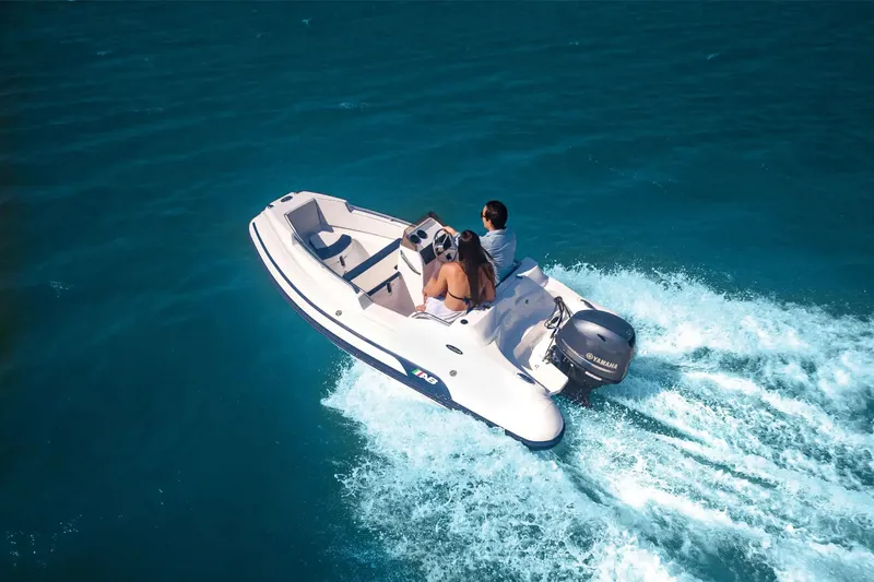 Slide: The Image of 2026 AB Inflatables Nautilus 13 DLX cruising on open water with two passengers. - 4