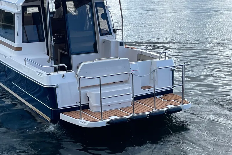 Slide: The Image of 2026 Ranger Tugs R-29 S boat on water, rear view with deck and railing. - 5