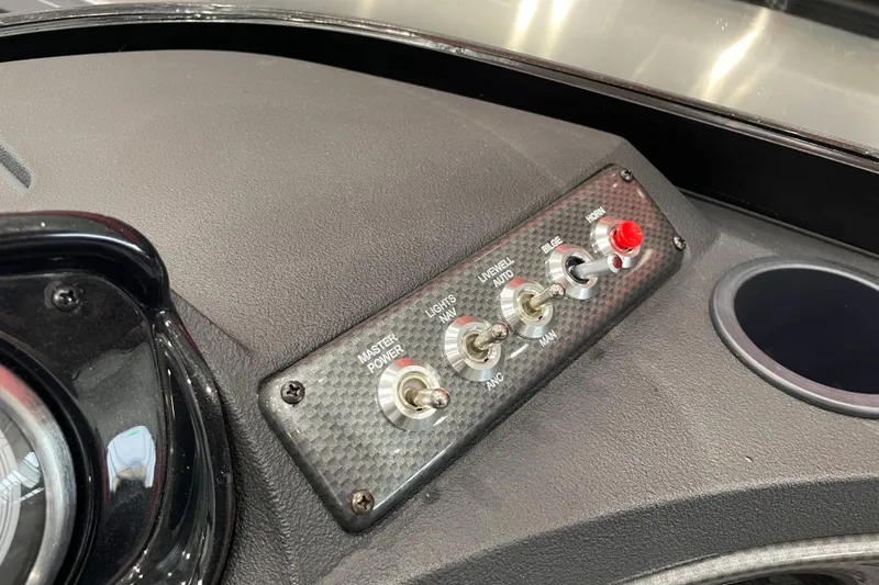 Slide: The Image of Dashboard controls of 2026 Crestliner 1750 Hawk WT J boat, featuring switches and cup holder. - 10