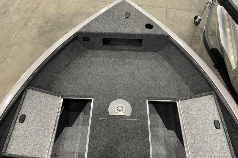 Slide: The Image of 2026 Crestliner 1750 Hawk WT J boat interior with storage compartments and carpeted deck. - 13