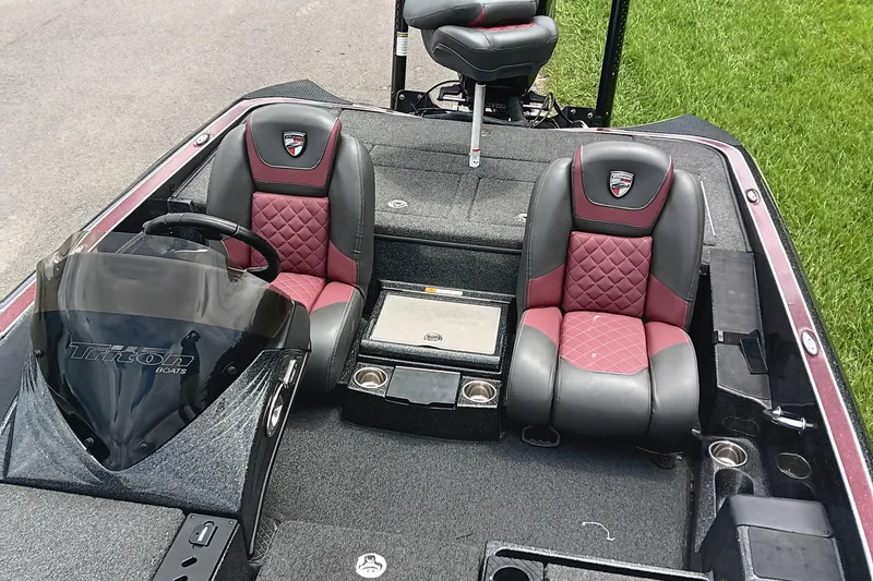 Slide: The Image of 2018 Triton 18 TrX boat interior with red and black seats, steering wheel, and console. - 11