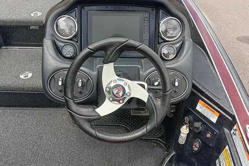 Slide: The Image of 2018 Triton 18 TrX boat dashboard with steering wheel and gauges. - 12