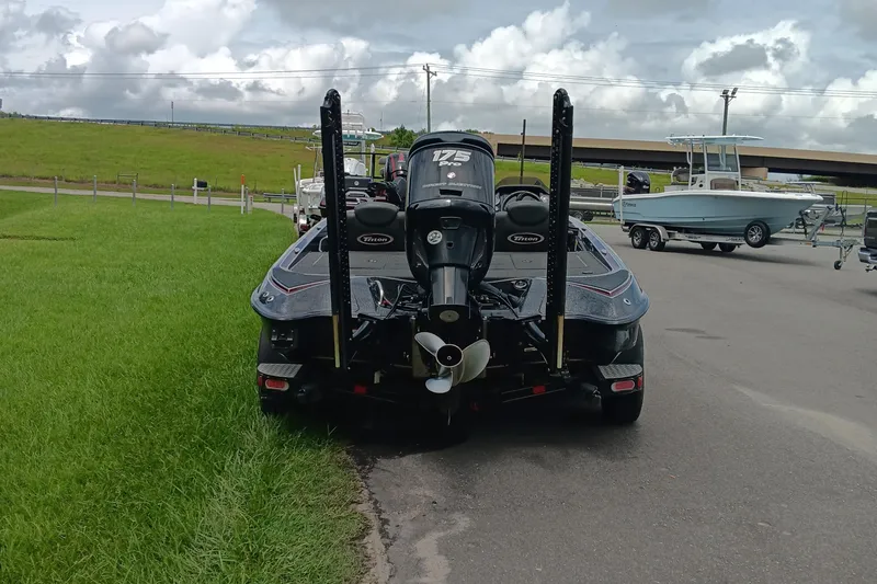 Slide: The Image of 2018 Triton 18 TrX boat with 175 HP engine, parked on a road near grass. - 4