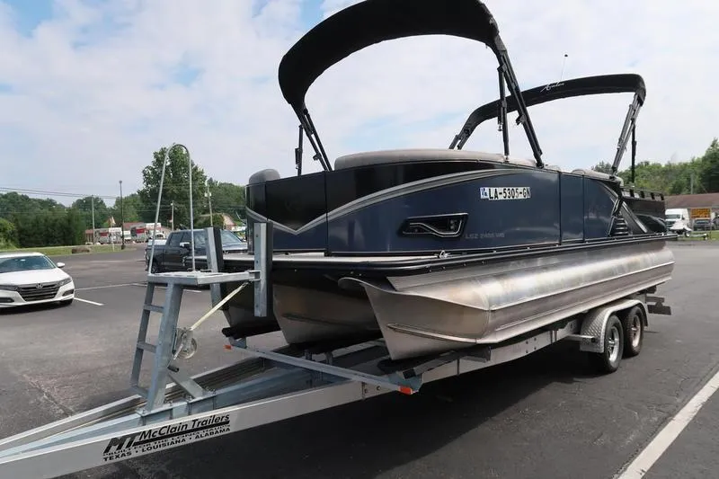 Slide: The Image of 2022 Avalon 26 LSV VRB pontoon boat on trailer in parking lot. - 2