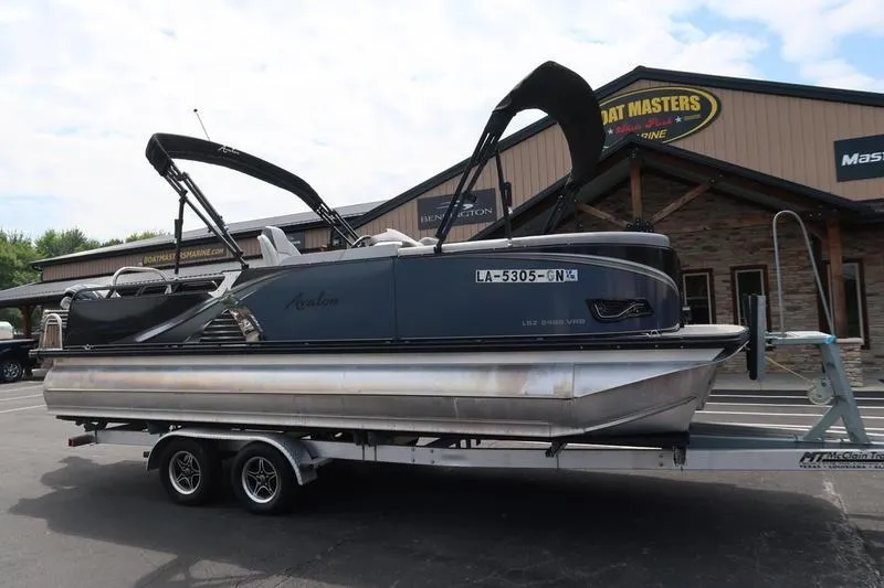 Slide: The Image of 2022 Avalon 26 LSV VRB pontoon boat on trailer outside dealership. - 3