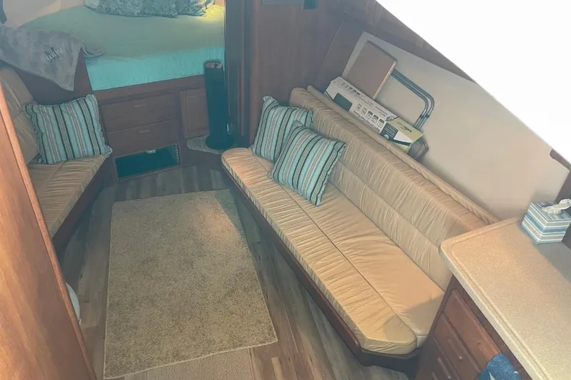 Slide: The Image of Interior of 1997 Luhrs 36 SX boat with cozy seating and striped cushions. - 14