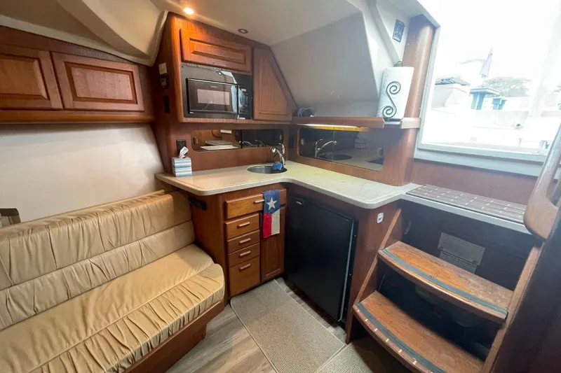 Slide: The Image of Interior of 1997 Luhrs 36 SX yacht with kitchenette, seating, and wooden cabinetry. - 21