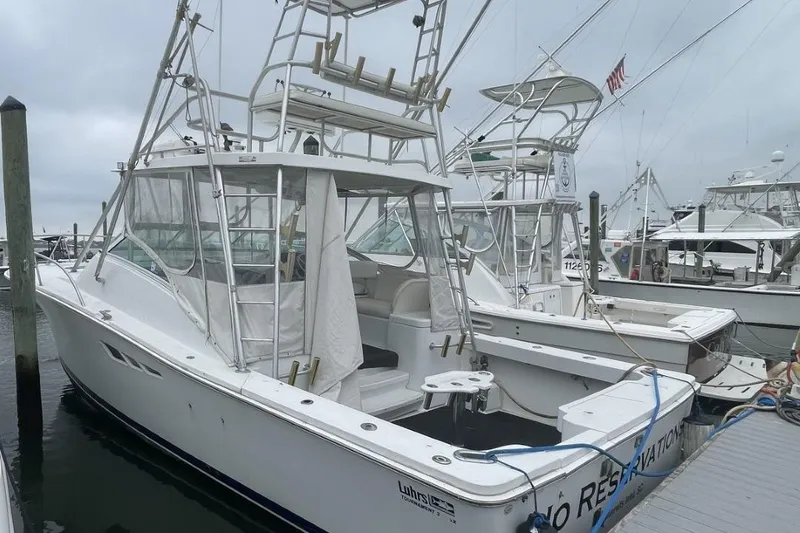 Slide: The Image of 1997 Luhrs 36 SX boat docked at marina on a cloudy day. - 3