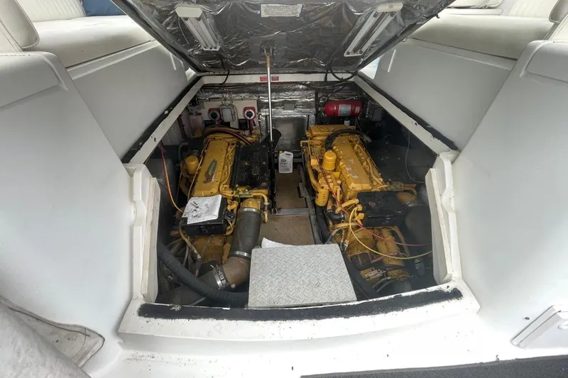 Slide: The Image of Engine compartment of a 1997 Luhrs 36 SX boat, featuring dual yellow engines. - 38